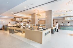 a restaurant with chefs working in the kitchen at Hotel Riu Palace Maspalomas - Adults Only in Maspalomas
