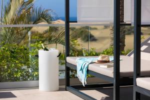 a hat sitting on a table on a balcony at Hotel Riu Palace Maspalomas - Adults Only in Maspalomas