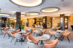 a restaurant with tables and chairs in a lobby at Hotel Riu Palace Maspalomas - Adults Only in Maspalomas