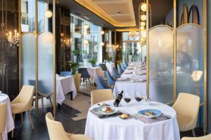 a row of tables in a restaurant with white tables and chairs at Hotel Riu Palace Maspalomas - Adults Only in Maspalomas