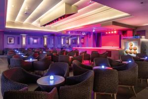 a room with chairs and tables and purple lighting at Hotel Riu Palace Maspalomas - Adults Only in Maspalomas