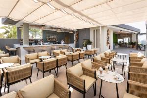 a restaurant with tables and chairs and a bar at Hotel Riu Palace Maspalomas - Adults Only in Maspalomas