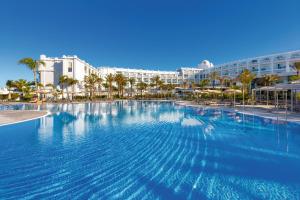 a large swimming pool in front of a resort at Hotel Riu Palace Maspalomas - Adults Only in Maspalomas