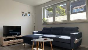 a living room with a blue couch and a tv at Schicht am Bach in Essen