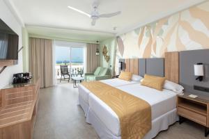 a hotel room with a bed and a television at Hotel Riu Palace Maspalomas - Adults Only in Maspalomas +37 photos