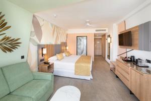 a hotel room with a bed and a couch at Hotel Riu Palace Maspalomas - Adults Only in Maspalomas