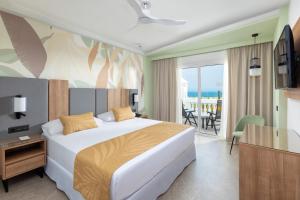 a bedroom with a bed and a view of the ocean at Hotel Riu Palace Maspalomas - Adults Only in Maspalomas