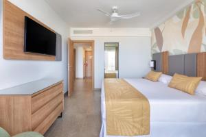 a bedroom with a bed and a flat screen tv at Hotel Riu Palace Maspalomas - Adults Only in Maspalomas