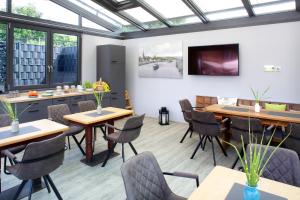 a dining room with tables and chairs and windows at OlfenLodge in Olfen