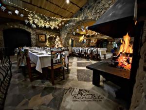 a restaurant with tables and chairs and a fireplace at Mi Ranchito Chignahuapan Hotel in Chignahuapan