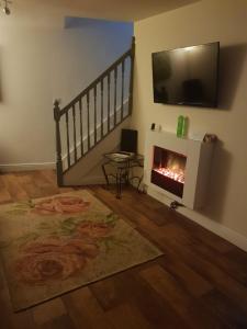 a living room with a fireplace and a television at Plover Cottage in Huddersfield