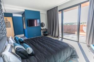 a bedroom with blue walls and a large bed with blue pillows at Villa familiale aux portes de Marrakech in Marrakesh
