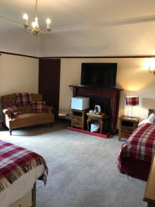 a living room with a couch and a flat screen tv at Cavell House in Inverness