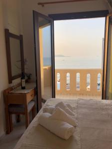 a bedroom with a bed with a view of the ocean at Anthoula Apartments in Kokkini Khanion