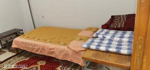 a room with a bed and a table with blankets at Tut flat in Luxor