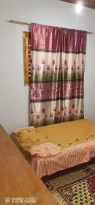 a bedroom with two beds and a curtain at Tut flat in Luxor