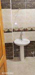a bathroom with a white sink in a room at Tut flat in Luxor