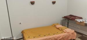 a bedroom with a bed with a yellow blanket at Tut flat in Luxor