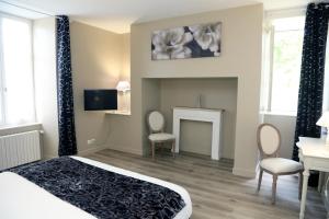 a bedroom with a bed and a fireplace at HOSTELLERIE LA BRUYERE in Chalvignac