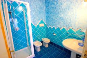 ein blaues Badezimmer mit Toilette und Waschbecken in der Unterkunft Residenza Sardegna da amare in Olbia