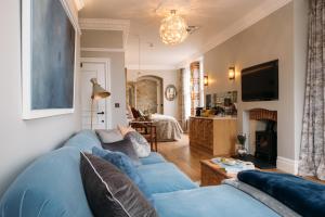 a living room with a blue couch and a tv at Host St Ives in St Ives
