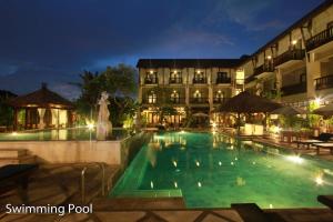 - une piscine en face de l'hôtel la nuit dans l'établissement The Lokha Legian Resort & Spa, à Legian