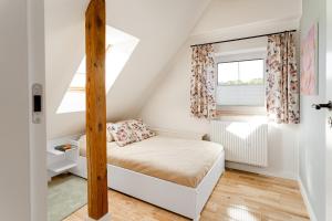 una piccola camera mansardata con letto e finestra di Stilvolles Haus ganz nah am Meer a Unieście