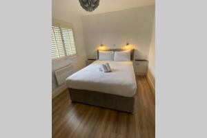 a bedroom with a bed with white sheets and a window at Apt 3 Silver Spruce - Killarney Town Free Parking in Killarney