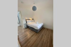 a bedroom with a white bed and a wooden floor at Apt 3 Silver Spruce - Killarney Town Free Parking in Killarney +2 photos