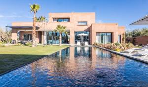 a house with a swimming pool in front of a house at Villa familiale aux portes de Marrakech in Marrakesh +5 photos