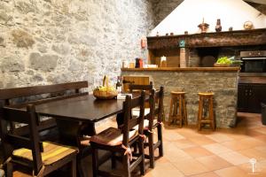 a dining room with a table and chairs and a kitchen at Casa da Edite in Ponta do Sol