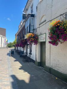 a building with flowers on the side of a street at Pilgrims Hotel in Canterbury