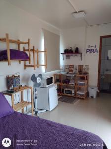 a room with a dorm room with a bed and a refrigerator at Morada Betel Box in Praia do Rosa