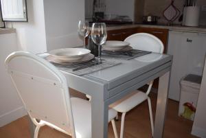a white table with two chairs and wine glasses at Studio Station 1 in Coimbra