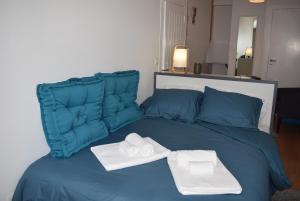 een blauw bed met twee handdoeken erop bij Studio Station 1 in Coimbra