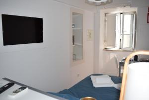 een ziekenhuiskamer met een bed en een flatscreen-tv bij Studio Station 1 in Coimbra