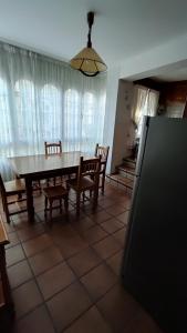 a dining room with a table and chairs and a refrigerator at Piso casco antiguo in Cedeira +4 photos
