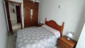 a bedroom with a bed and a dresser and a door at Piso casco antiguo in Cedeira
