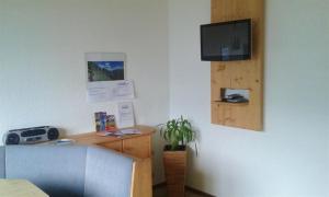 een kamer met een bureau en een tv aan de muur bij Ferienwohnung Dengg in Stummerberg