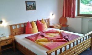 een bed met kleurrijke kussens in een slaapkamer bij Ferienwohnung Dengg in Stummerberg