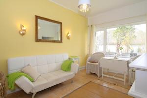 a living room with a white couch and a table at Teewelkenhues-Wiesenappartement in Archsum