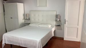 a white bed with two pillows on it in a room at Apartamento Elena 11 in Lajares