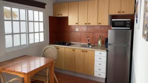 a kitchen with a stainless steel refrigerator and a table at Apartamento Elena 11 in Lajares +2 photos