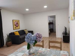 a living room with a vase of purple flowers on a table at c Apartamentos Diego in O Grove
