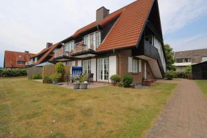 una casa con un gran patio delante de ella en Haus-Suedstrand-Appartement-12, en Westerland