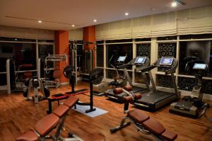 a gym with several treadmills and machines in a room at Dushanbe Serena Hotel in Dushanbe