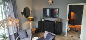 a living room with a tv and a couch and chairs at Apartment Sanctus Nicolaus with sauna in Rovaniemi