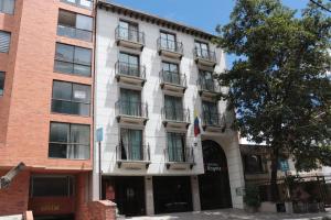 a tall white building with balconies on it at Hoteles Bogotá Inn El Lago Country in Bogotá