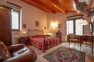 a bedroom with a bed and a couch and a chair at Il Belvedere in Civita