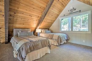 two beds in a room with a wooden ceiling at Airy Alpine Getaway with Lake Arrowhead Views! in Lake Arrowhead